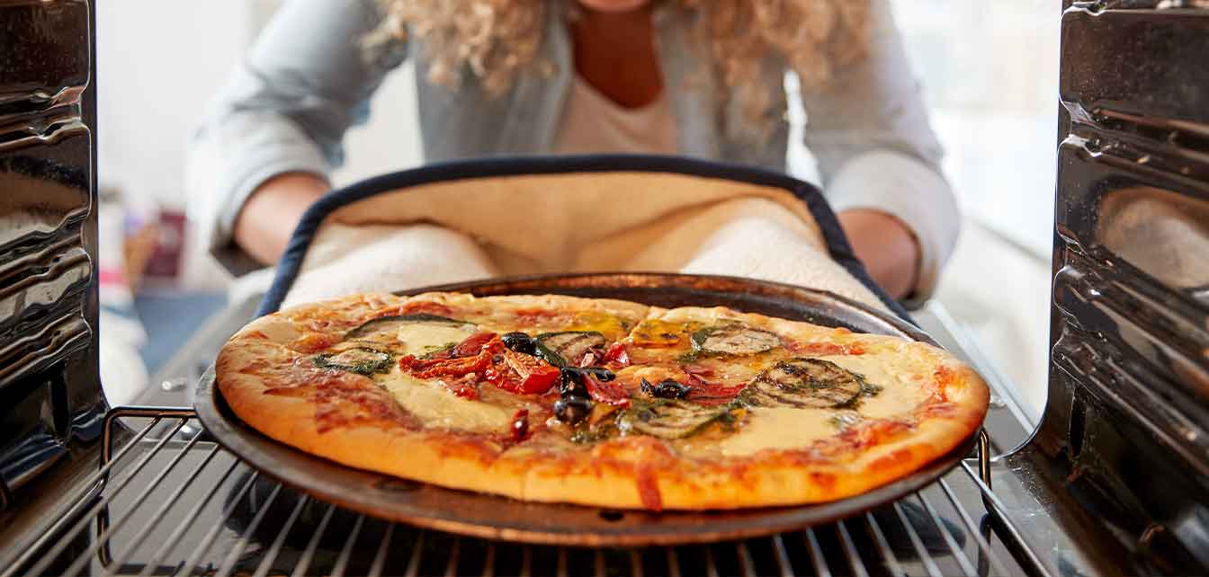 Removing baked pizza from oven